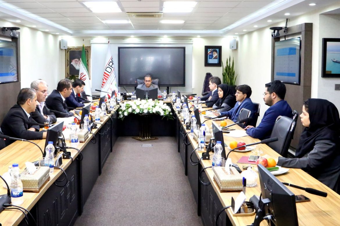 لوگوی شرکت معدنی و صنعتی چادرملو در کنار تصویری از یک معدن سنگ آهن و پنل‌های خورشیدی