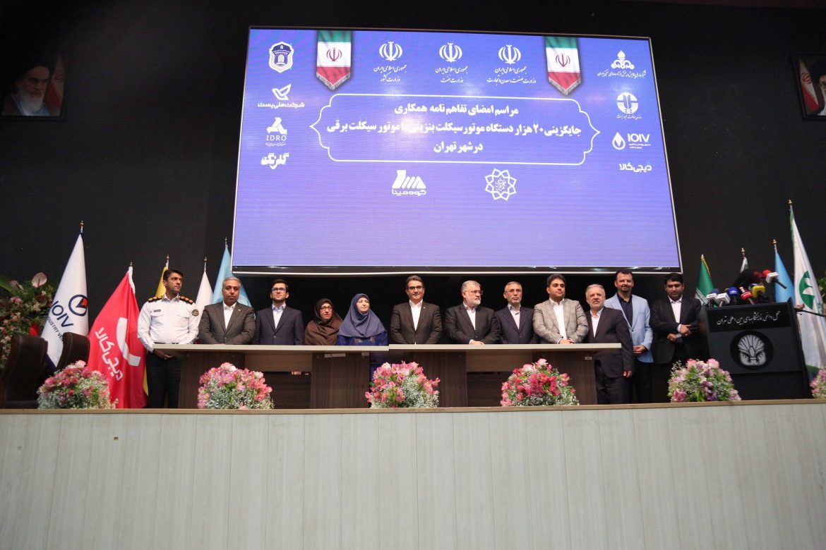 موتورسیکلت برقی در حال شارژ با پس‌زمینه تهران پاک